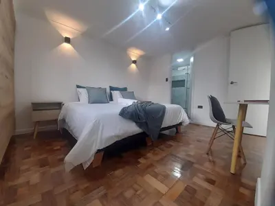 a bedroom with a large bed and a desk at In the center of Poblado in Medellín