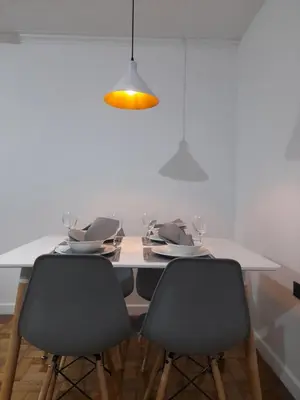a dining room table with two chairs and a light fixture at In the center of Poblado in Medellín