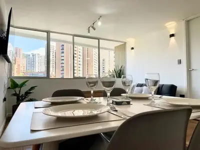 a dining room table with wine glasses on it at In the center of Poblado in Medellín