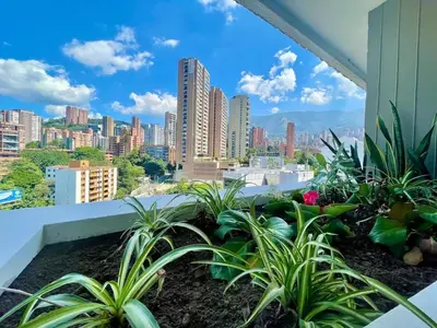 a balcony with plants and a view of a city at In the center of Poblado in Medellín