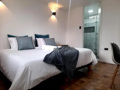 a bedroom with a large bed and a glass shower at In the center of Poblado in Medellín