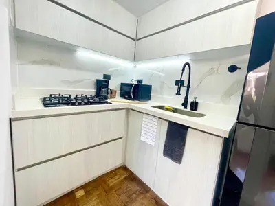 a kitchen with white cabinets and a sink and a stove at In the center of Poblado in Medellín