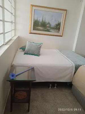 a small bedroom with a bed and a table at Grillo Grillo el amarillo in Medellín