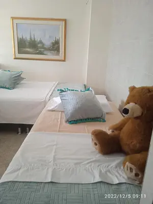 a teddy bear sitting on a bed in a bedroom at Grillo Grillo el amarillo in Medellín