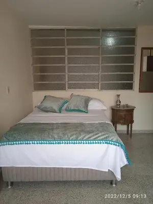 a bedroom with a large bed and a table at Grillo Grillo el amarillo in Medellín