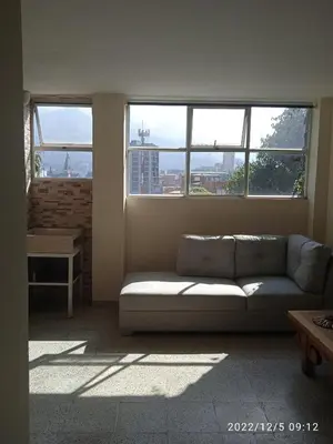 a living room with a couch in front of a window at Grillo Grillo el amarillo in Medellín