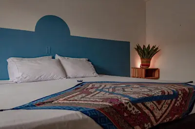 a bedroom with a bed with a blue headboard at Hotel Casa Encanto Jardín in Jardin