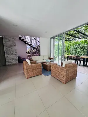 a living room with wicker furniture and a fireplace at Finca de lujo con picsina en San Jerónimo Antioquia in San Jerónimo