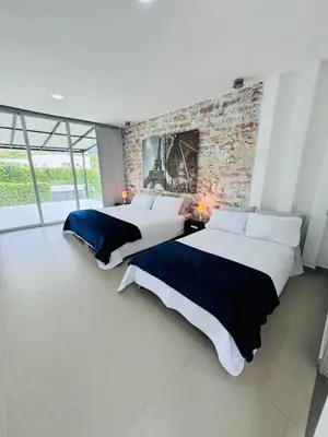 two beds in a room with a brick wall at Finca de lujo con picsina en San Jerónimo Antioquia in San Jerónimo