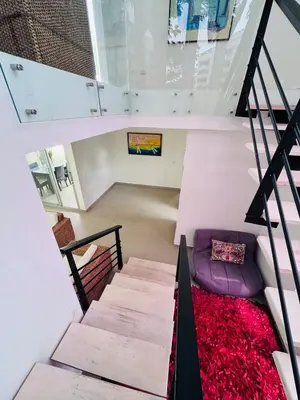 a staircase in a house with a purple couch at Finca de lujo con picsina en San Jerónimo Antioquia in San Jerónimo