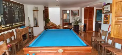 a pool table in a room with chairs at Finca Villla las Palmas in Chiquinquirá