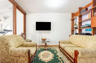 a living room with two couches and a flat screen tv at Casa La Palma Habitación Altillo in Medellín