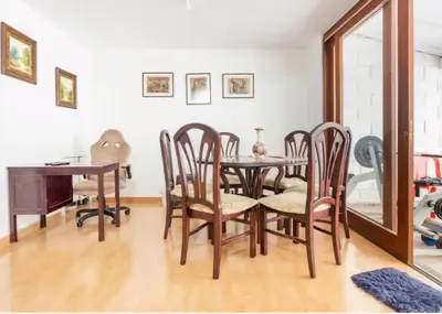 a dining room with a table and chairs and a mirror at Casa La Palma Habitación Altillo in Medellín