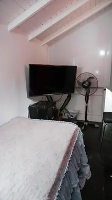 a bedroom with a bed and a flat screen tv at Casa La Palma Habitación Altillo in Medellín