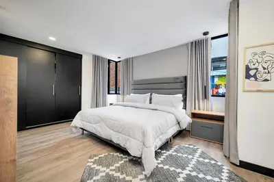 a bedroom with a large white bed and a rug at Moderno-Central El Poblado Apartamento in Medellín