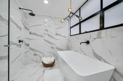 a bathroom with a white sink and marble walls at Moderno-Central El Poblado Apartamento in Medellín