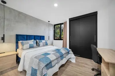 a bedroom with a bed and a desk and a window at Moderno-Central El Poblado Apartamento in Medellín