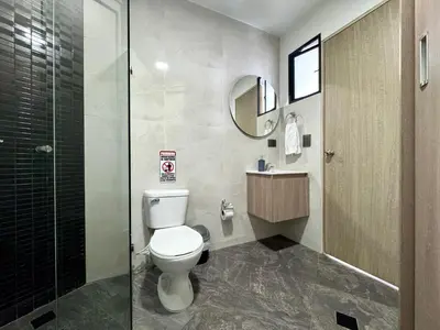 a bathroom with a toilet and a glass shower at Praga Room Unicentro in Medellín