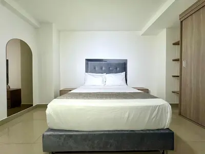 a bedroom with a large bed in a room at Praga Room Unicentro in Medellín