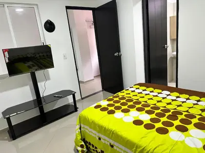 a bedroom with a bed and a television in it at Lorena Apartamento in El Peñol