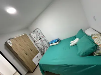 a bedroom with a green bed with a wooden door at Lorena Apartamento in El Peñol