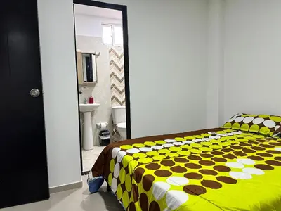 a bedroom with a yellow and white comforter on a bed at Lorena Apartamento in El Peñol