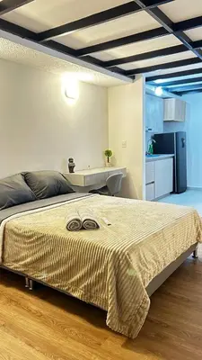 a bedroom with a large bed and a kitchen at Lujoso, relajante y Cómodo Apartaestudio en La Rambla in Manizales