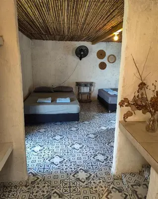a room with a bed and a table on a tiled floor at Finca Rústica, Cocorná - Cacao, Charcos y Cascadas in Cocorná