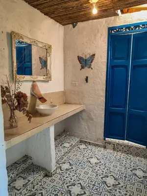 a bathroom with a sink and a blue door at Finca Rústica, Cocorná - Cacao, Charcos y Cascadas in Cocorná