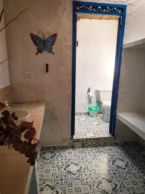 a bathroom with a butterfly on the wall and a toilet at Finca Rústica, Cocorná - Cacao, Charcos y Cascadas in Cocorná