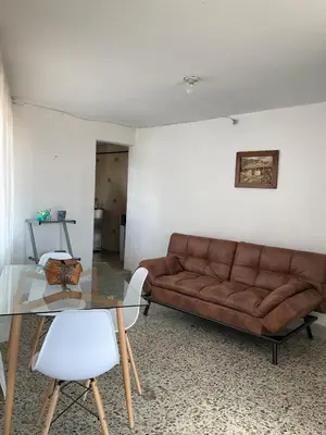 a living room with a brown couch and a glass table at Apartamento cómodo en Medellín in Medellín