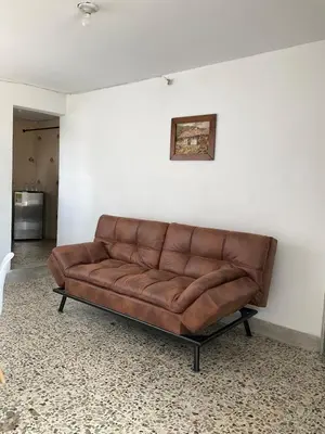 a brown leather couch sitting in a room at Apartamento cómodo en Medellín in Medellín