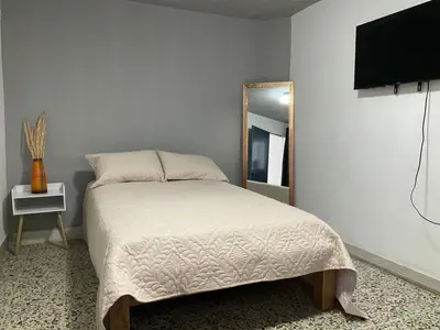 a bedroom with a bed and a mirror at Apartamento cómodo en Medellín in Medellín
