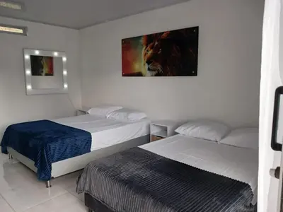 a room with two beds and a painting on the wall at Hermosa Casa de descanso Villa María in Don Matías