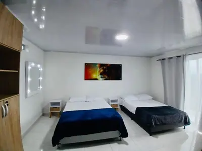 a bedroom with two beds and a painting on the wall at Hermosa Casa de descanso Villa María in Don Matías
