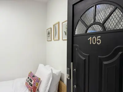a bedroom with a black door and a bed with white pillows at Apartaestudio 105- Casa Bendita in Medellín