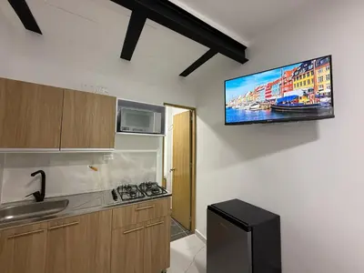 a kitchen with a tv hanging on the wall at Apartaestudio 105- Casa Bendita in Medellín