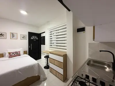 a bedroom with a bed and a kitchen with a sink at Apartaestudio 105- Casa Bendita in Medellín