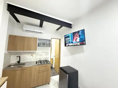 a kitchen with a sink and a tv on the wall at Apartaestudio 105- Casa Bendita in Medellín
