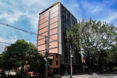 a tall building on the corner of a street at Cozy Comforts at Rosa Negra Stadio in Medellín
