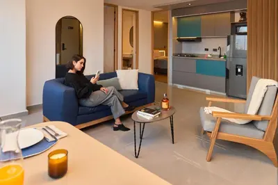 a man sitting on a blue couch in a living room at Stadio Aparta-Suite Bliss Rosa Negra in Medellín