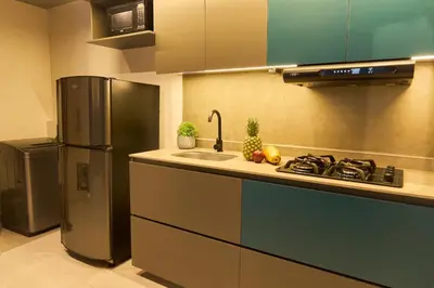 a kitchen with a refrigerator and a sink at Inviting Stadio Suite Rosa Negra in Medellín