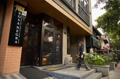 a man walking in front of a store at Inviting Stadio Suite Rosa Negra in Medellín