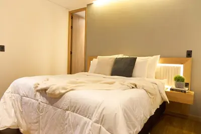 a bedroom with a bed with white sheets and a window at Cozy Stadio Escape Rosa Negra Stay in Medellín