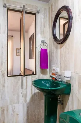 a bathroom with a green sink and a mirror at Studio apartment in La Floresta near the subway in Medellín