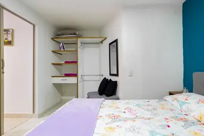 a bedroom with a bed and a chair in it at Studio apartment in La Floresta near the subway in Medellín
