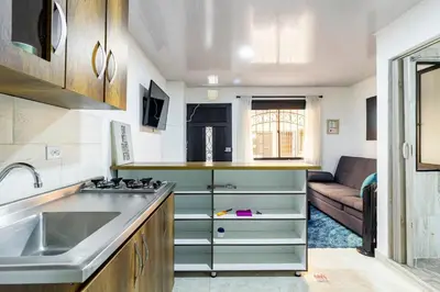 a kitchen with a sink and a couch in a room at Studio apartment in La Floresta near the subway in Medellín