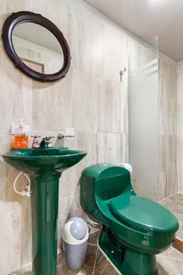 a green toilet and a sink in a bathroom at Studio apartment in La Floresta near the subway in Medellín