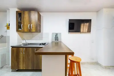 a kitchen with wooden cabinets and a counter top at Studio apartment in La Floresta near the subway in Medellín