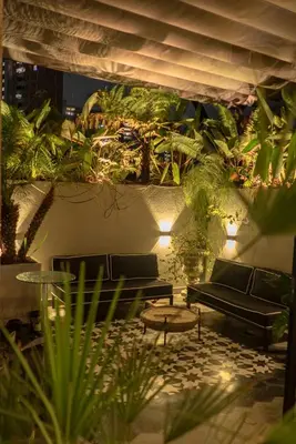 a patio with couches and a table and plants at Vive Pisoverde - a Loft with a green soul in Medellín